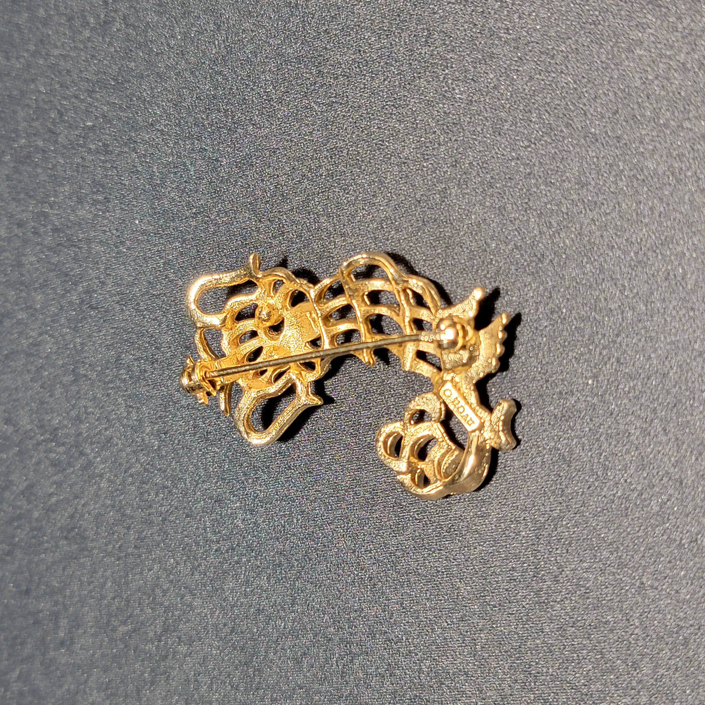 Close-up showing green rhinestone eyes and filigree detail